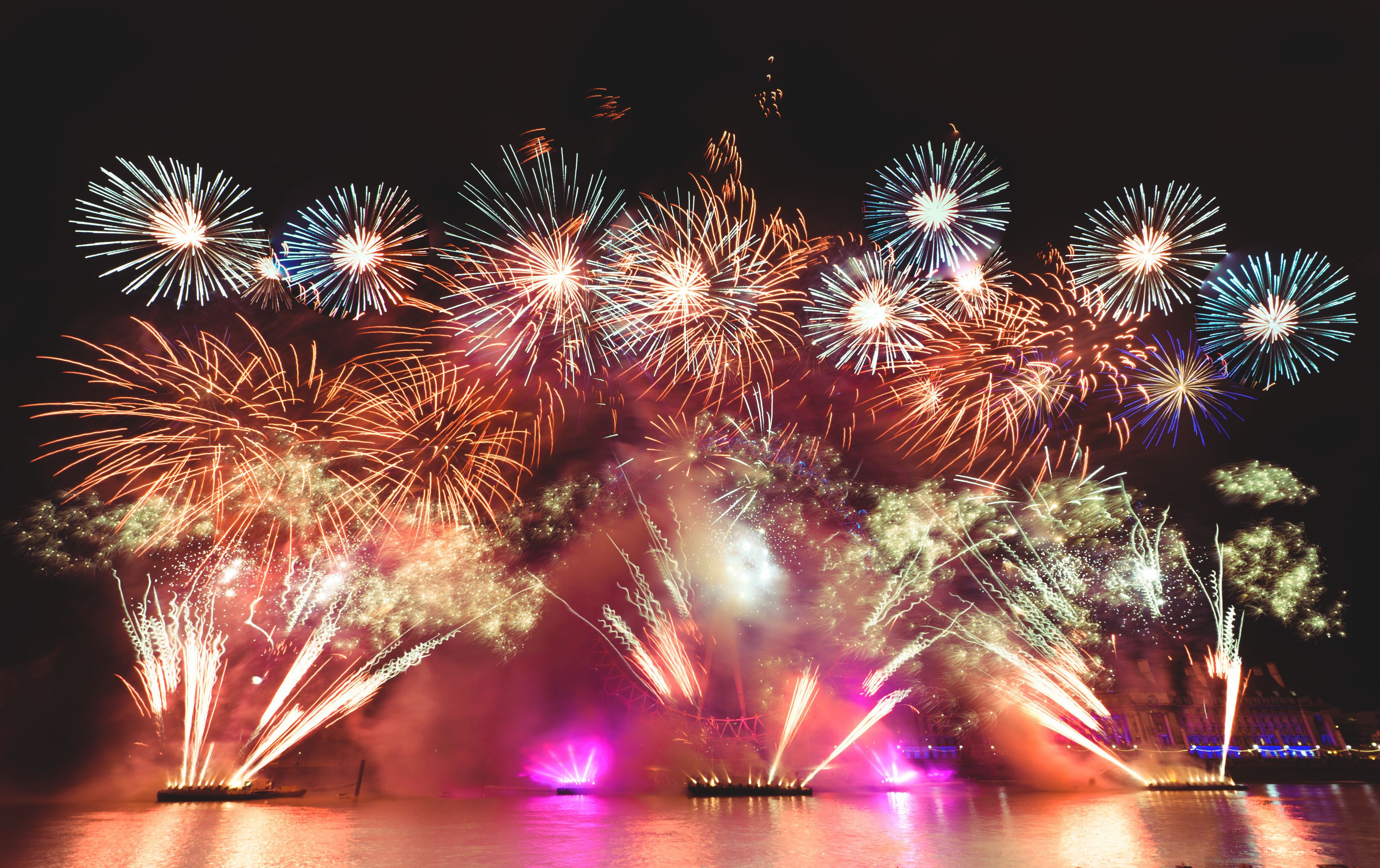 Colorful New Year's Eve fireworks lighting up the night sky over London's iconic London Eye