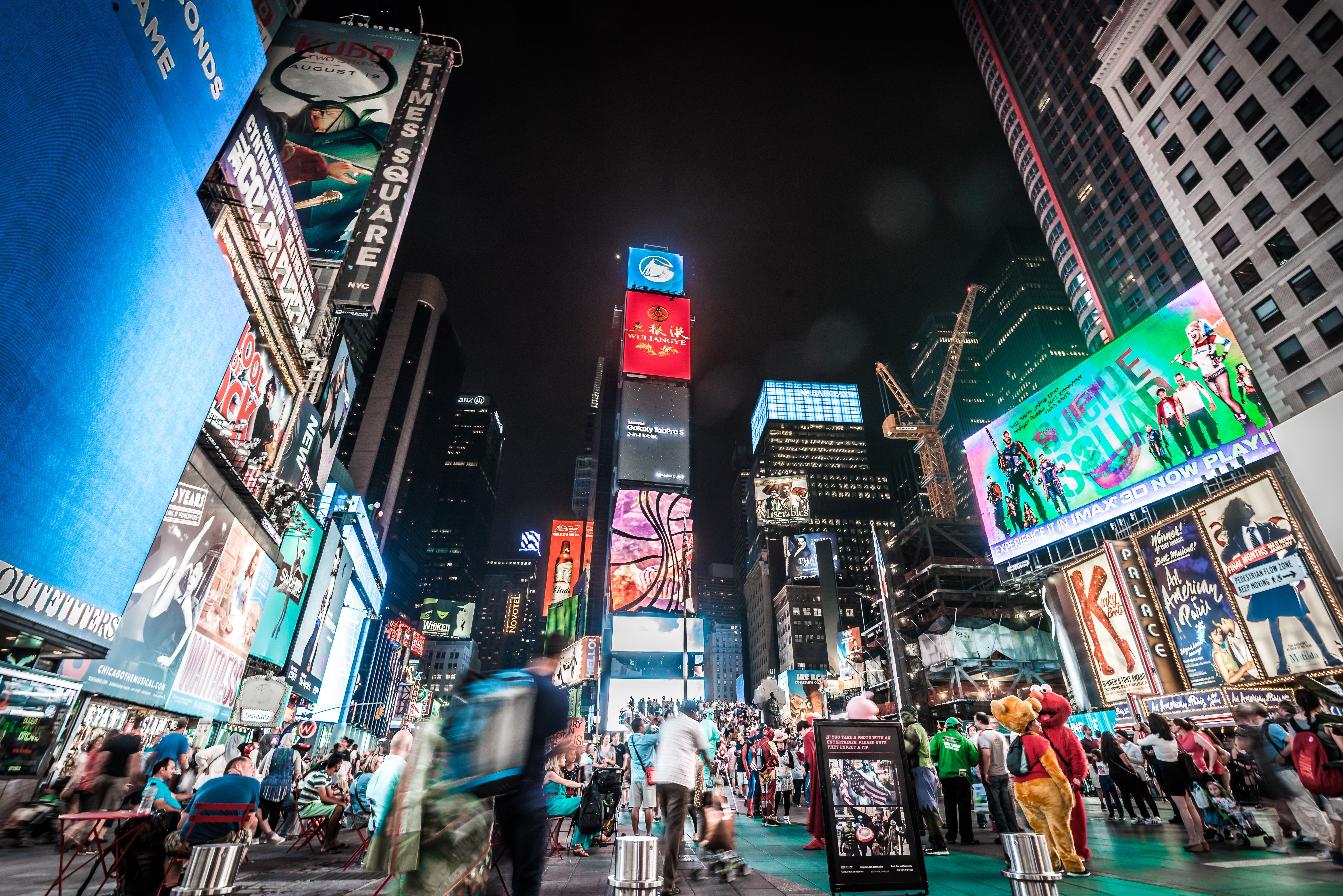 Times Square in New York City glowing with bright billboards and crowds at night for New Year's Eve